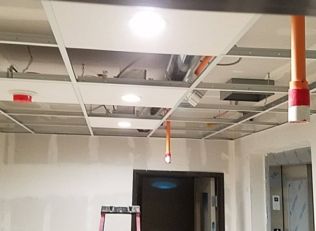 Recessed lighting installed in a suspended ceiling grid during a commercial build-out